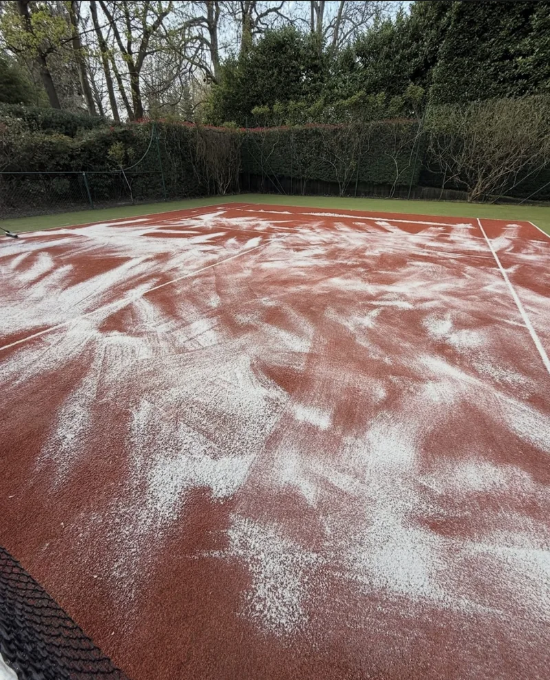 Tratamiento de una pista de tenis con producto distribuido sobre la superficie